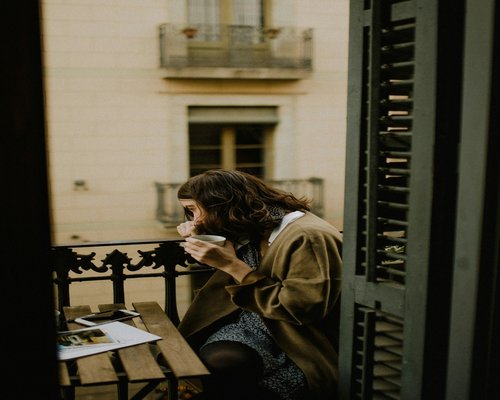 A person enjoying a quiet morning coffee by the window