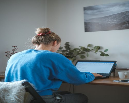 Person stretching gently at home office desk